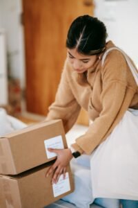 Female customer with shopping bag getting stack of carton boxes with delivered goods at home